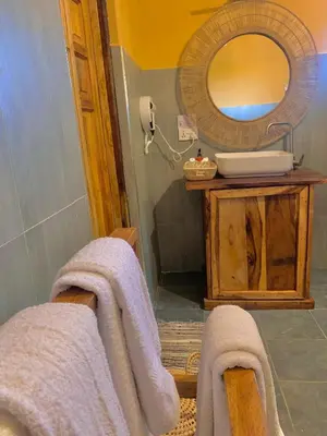 a bathroom with a sink and a mirror and towels at Africa Safari Arusha in Arusha