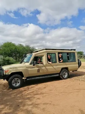 a group of people are sitting in a jeep at Hakuna Woga Inn in Arusha