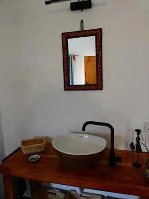 a bowl sink on a wooden table with a mirror at Hakuna Woga Inn in Arusha