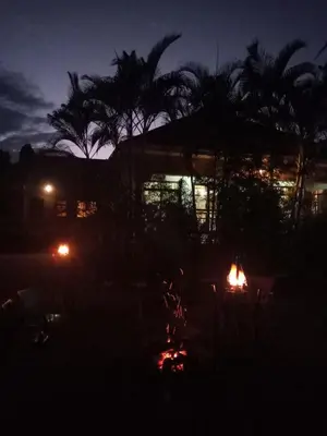 a house lit up at night with palm trees at Africa Lodge Arusha in Nkoaranga
