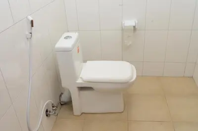 a white bathroom with a toilet and a sink at Kilimanjaro White House Hotel in Moshi