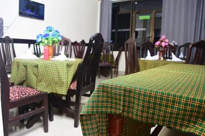 a restaurant with two tables and chairs with flowers on them at Kilimanjaro White House Hotel in Moshi