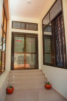 a lobby with stairs and windows in a building at Kilimanjaro White House Hotel in Moshi
