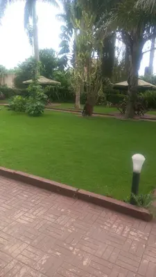 a park with green grass and a trash can at New Charity Hotel International in Arusha