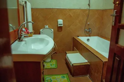 a bathroom with a sink and a toilet and a tub at New Charity Hotel International in Arusha