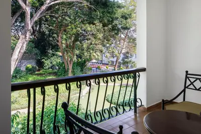 a balcony with a table and chairs and trees at Four Points by Sheraton Arusha, The Arusha Hotel in Arusha
