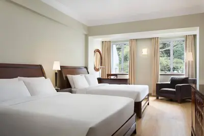 a hotel room with two beds and a chair at Four Points by Sheraton Arusha, The Arusha Hotel in Arusha