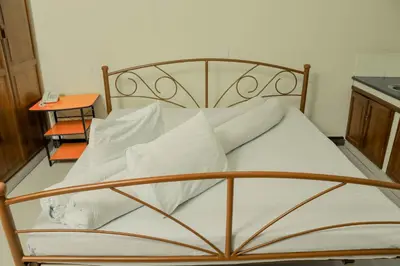 a bed with white sheets and pillows in a room at Maresi Luxury Hotel in Arusha