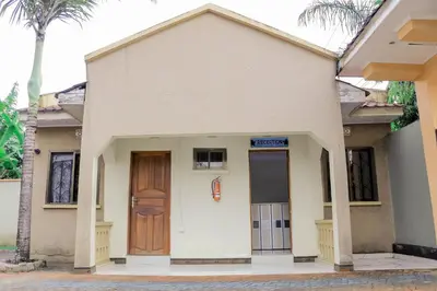 a small white house with a wooden door at Maresi Luxury Hotel in Arusha