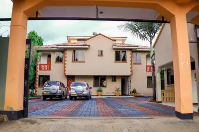 two cars parked in front of a house at Maresi Luxury Hotel in Arusha