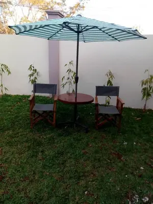 a table and two chairs under an umbrella at Sumawe Suites in Karatu
