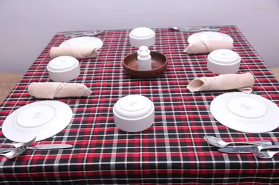 a table with plates and napkins on a plaid table cloth at Sumawe Suites in Karatu
