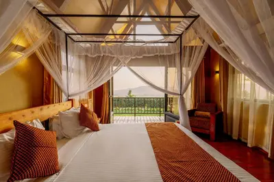 a bedroom with a canopy bed and a balcony at Shamba Lodge Cabin B in Arusha