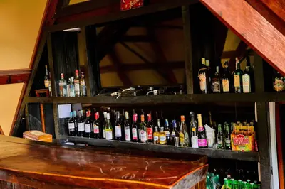 a shelf filled with lots of bottles of alcohol at Shamba Lodge Cabin B in Arusha