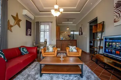 a living room with a red couch and a tv at Kinga Homes Boutique Hotel in Moshi