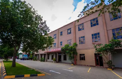 a large building with a parking lot in front of it at Panone Hotels - King'ori Kilimanjaro Airport in Moshi