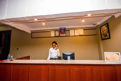 a woman talking on a cell phone in an office at Panone Hotels - King'ori Kilimanjaro Airport in Moshi
