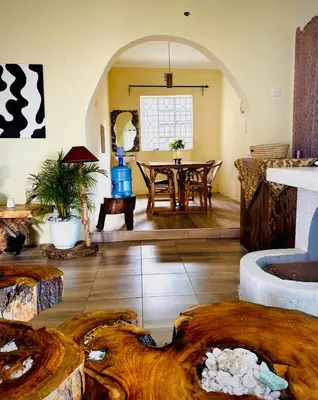 a living room with a table and a wooden floor at Nguruma house of travellers and tours in Arusha