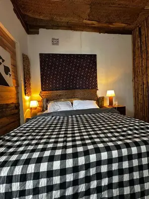 a bedroom with a black and white checkered bed at Nguruma house of travellers and tours in Arusha