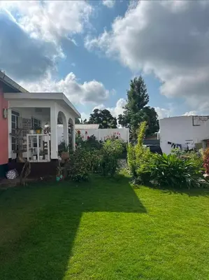 a yard with a house with a grassy yard at Nguruma house of travellers and tours in Arusha
