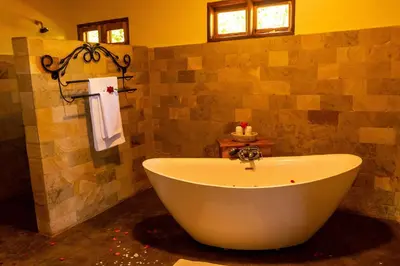 a bathroom with a large tub in a room at Ngorongoro Marera Mountain View Lodge in Karatu