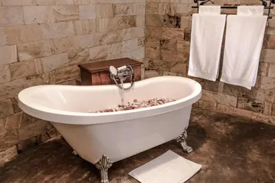 a bath tub with a faucet in a bathroom at Ngorongoro Marera Mountain View Lodge in Karatu