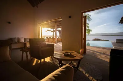 a living room with a couch and a table and a large window at Manyara's Secret in Mto wa Mbu