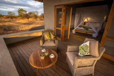 a room with a table and chairs and a bed at Manyara's Secret in Mto wa Mbu