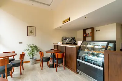 a restaurant with a counter and a table and chairs at Kibo Palace Hotel Moshi in Moshi