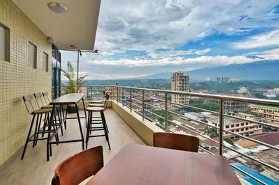 a balcony with tables and chairs and a view of a city at Kibo Palace Hotel Moshi in Moshi