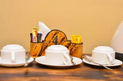 three cups and saucers on a table with a basket at Burka Coffee Lounge in Arusha