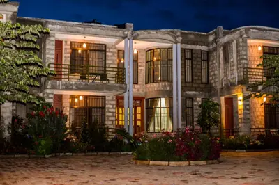 a large white building with flowers in front of it at Burka Coffee Lounge in Arusha