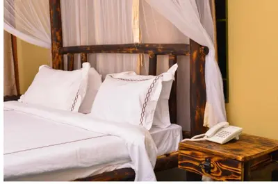 a bedroom with a bed and a phone on a table at Burka Coffee Lounge in Arusha