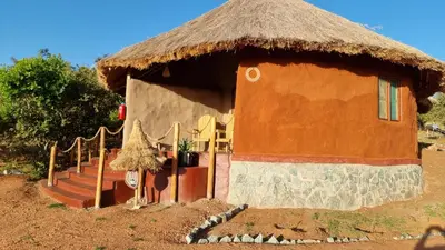 a small hut with a thatched roof and stairs at Africa Safari Maasai Boma in Serengeti