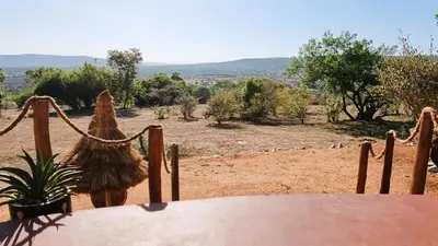 a table with a potted plant and a view of a field at Africa Safari Maasai Boma in Serengeti