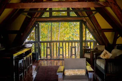 a living room with a large window in a cabin at Shamba Lodge Cabin C in Olmotoni