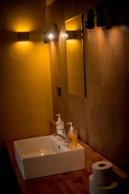 a bathroom with a white sink and a mirror at Shamba Lodge Cabin C in Olmotoni