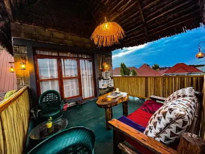 a room with a couch and a table on a balcony at Home Villa Eco Boutique in Arusha
