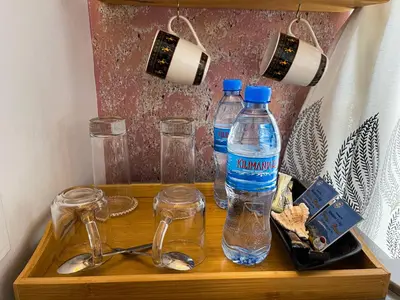 two bottles of water and glasses on a wooden tray at Home Villa Eco Boutique in Arusha