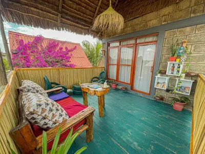a porch of a house with a chair and a table at Home Villa Eco Boutique in Arusha