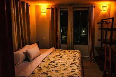 a bedroom with a bed with pillows and a window at Dual Mountain View Lodge in Moshi