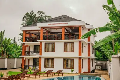 a building with a pool in front of it at Dual Mountain View Lodge in Moshi