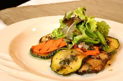 a plate of food with vegetables on a table at Mount Meru Hotel in Arusha