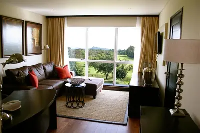 a living room with a couch and a large window at Mount Meru Hotel in Arusha