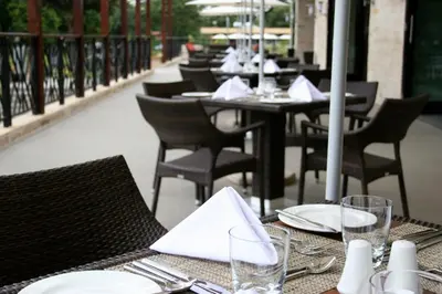 a table with plates and napkins on top of a restaurant at Mount Meru Hotel in Arusha