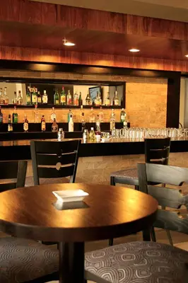 a restaurant with a wooden table and a bar at Mount Meru Hotel in Arusha