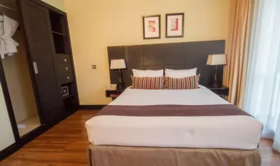 a bedroom with a large bed and two lamps at Mount Meru Hotel in Arusha