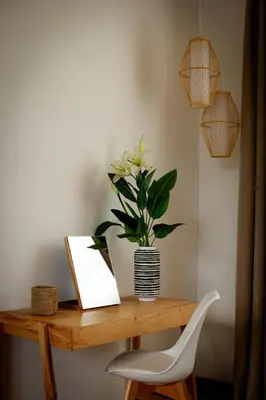 a wooden table with a vase of flowers and lights at The Safari House in Usa River
