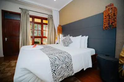 a hotel room with a bed with a zebra print blanket at Arusha Planet Lodge in Arusha