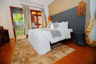 a bedroom with a large white bed and a window at Arusha Planet Lodge in Arusha